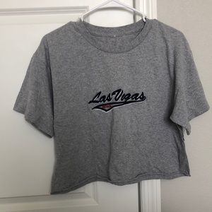 gray cropped shirt with cursive lettering